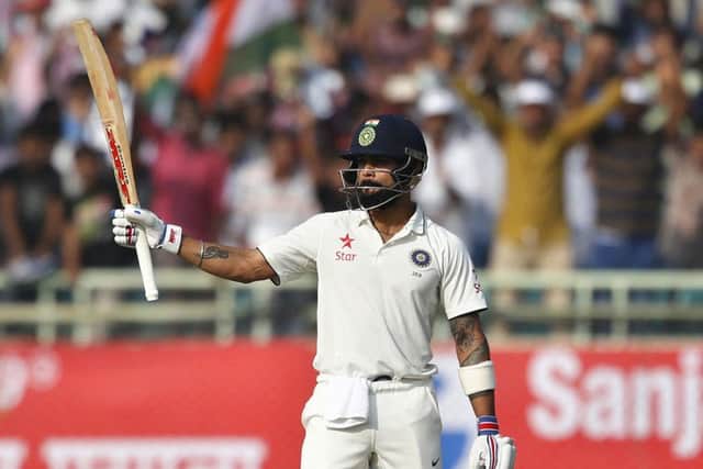MASTERFUL: India's captain Virat Kohli raises his bat to celebrate scoring a century during the second Test in Visakhapatnam. Picture: AP/Aijaz Rahi