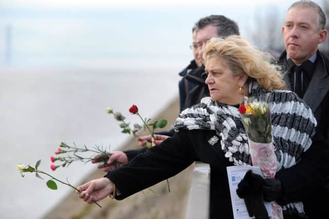 Jill Long throws floral tributes into the Humber