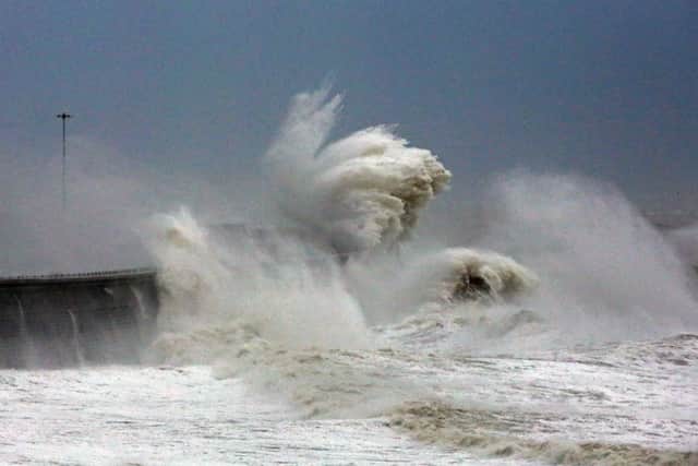 Waves crash over the harbour wall in Dover