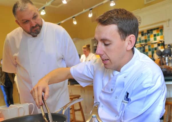 Alex Krol  (right)  taking part in the Help For Heroes cookery competition at the Swinton Park Hotel Cookery School  near Masham being watched by  Giles Farrington from York a competitor in the competition two years ago.