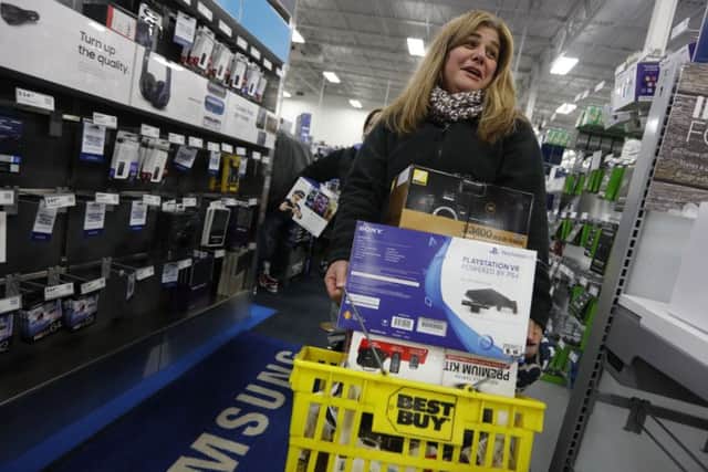 Sandy Costeira has her hands full with purchases as she makes her way through Best Buy on Black Friday