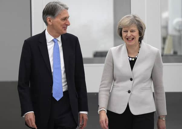 Prime Minister Theresa May and Chancellor of the Exchequer Philip Hammond tour a factory after an Autumn Statement designed to put 'just about managing' families first.