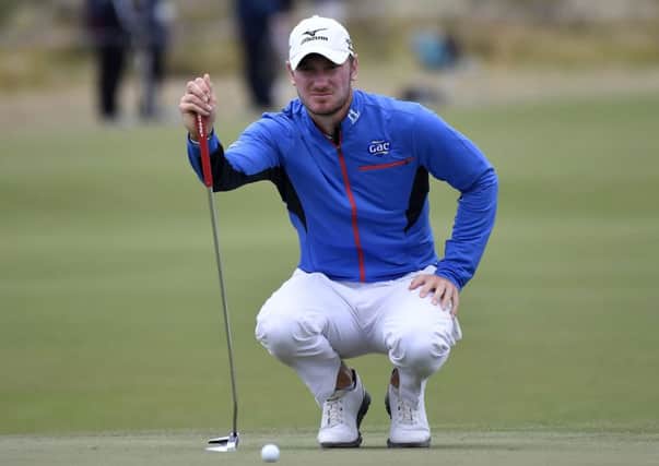 Chris Wood studies the line of his putt as he and England team-mate Andy Sullivan stayed in contention in Melbourne. (Picture: AP)