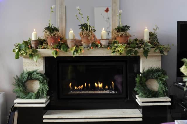 The fireplace with Jo's favourite vintage terracotta pots planted with candles and Christmas roses