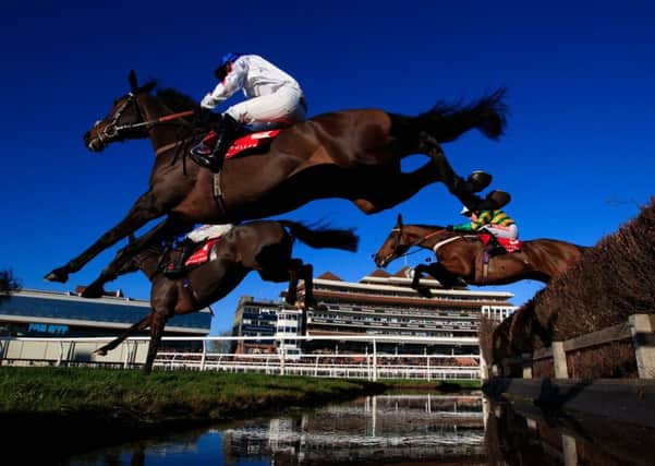 Clan Des Obeaux (white) ridden by Sean Bowen jumps the water jump during The bet365 Festival at Newbury Racecourse.