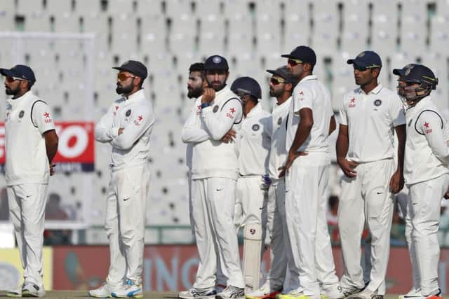 Indian cricketers watch a giant screen as they wait for third umpires decision for England's captain Alastair Cook's lbw appeal on the third day in Mohali, India. (AP Photo/Altaf Qadri)