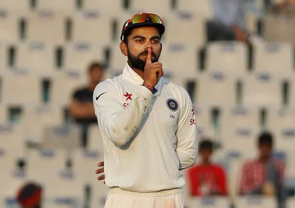 India's test cricket team captain, Virat Kohli, gestures at his supporters to remain silent, after England's Ben Stokes got out on the third day of their third cricket test match in Mohali