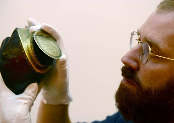 Experience Barnsley museum curator Stephen Miller with a pit pony's foot, recovered from the disaster and turned into an ink well. Picture: Scott Merrylees.