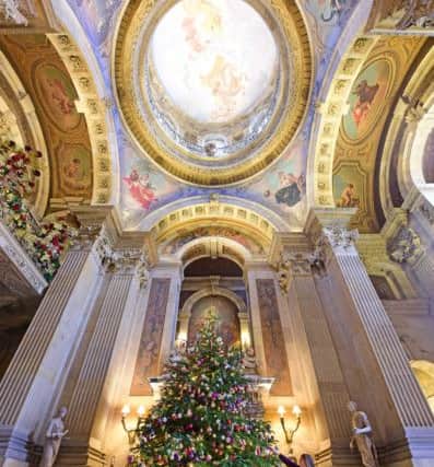 Hannah Cooke of Castle Howard adjusts one of the 1500 baubles on the huge tree inside the Great Hall.Picture: Anthony Chappel-Ross