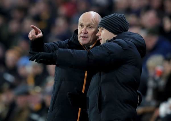 Hull City manager Mike Phelan speaks with fourth official Stuart Attwell during Tuesday night's quarter-final win against Newcastle Untied at the KCOM Stadium. Picture: Mike Egerton/PA