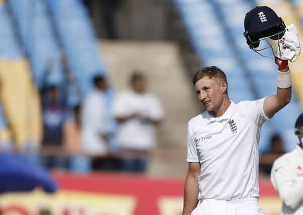 England's batsman Joe Root raises his helmet after scoring hundred runs during the first day of the first test cricket match between India and England in Rajkot. (AP Photo/Rafiq Maqbool)