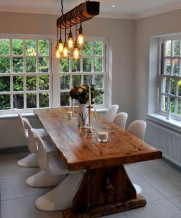 The light above the dining table is made from a log and industrial-style lighting