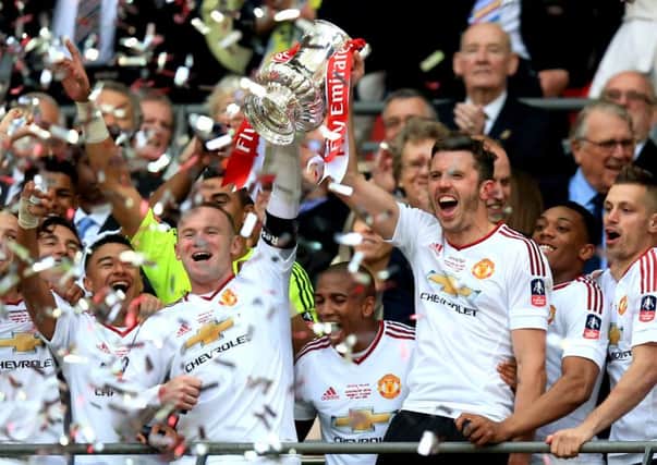 Manchester United's Wayne Rooney (left) and Michael Carrick (right) lift the FA Cup after defeating Crystal Palace 2-1 in extra-time at Wembley in May this year. Picture: Mike Egerton/PA.