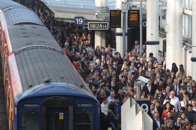 Commuters pile onto a train