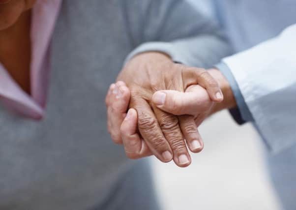 Closeup of an elderly woman's hand being held by a doctor , focus on hands