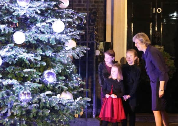 Prime Minister Theresa May turns on the Downing Street Christmas tree lights with the Prime Minister Christmas Card Competition winners (left to right) Jade Winsor (11), Isabelle Milnes (5) and Sophie Brazil (11), in central London.