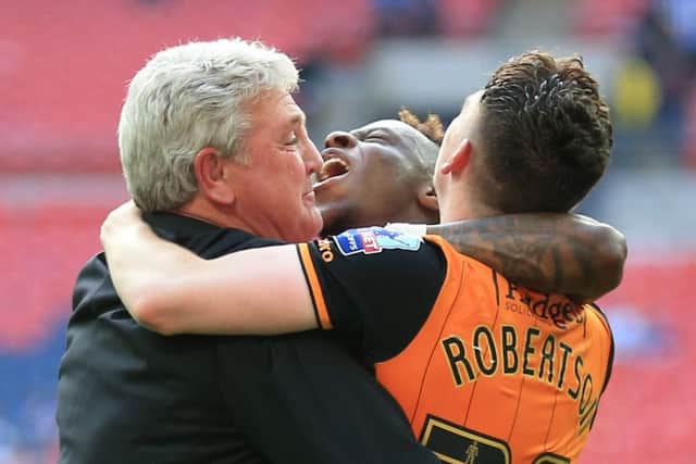 Hull City manager Steve Bruce celebrates with Moses Odubajo, centre, and Andrew Robertson after winning the Championship play-off final at Wembley.