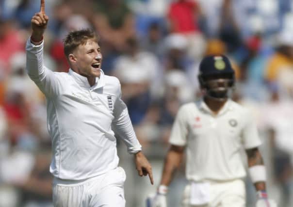 England's bowler Joe Root, left, celebrates the wicket of Indian batsman Parthiv Patel on the third day of the fourth cricket test match between India and England in Mumbai, India, Saturday, Dec. 10, 2016. (AP Photo/Rafiq Maqbool)