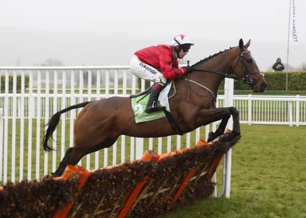 The New One ridden by Richard Johnson clears an early flight on the way to winning The stanjames.com International Hurdle Race run during day two of the International meeting at Cheltenham Racecourse.