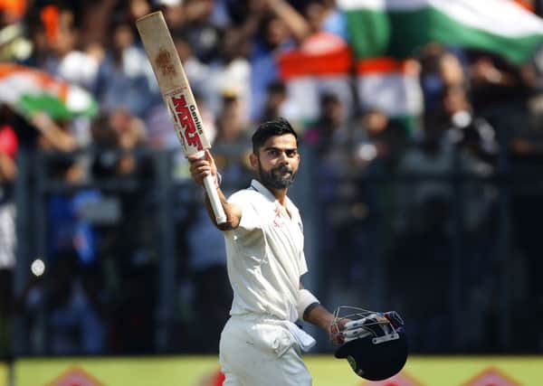 Indian cricket captain Virat Kohli raises his bat as he walks back after losing his wicket on the fourth day of the fourth cricket test match between India and England in Mumbai. (AP Photo/Rafiq Maqbool)