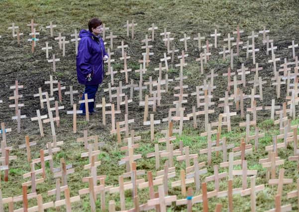 12 Dec 2016.....A beacon is lit and 384 crosses are planted to mark the 150th anniversary of the Oakes Pit Disaster in Barnsley. A member of the public amongst the crosses. Picture Scott Merrylees