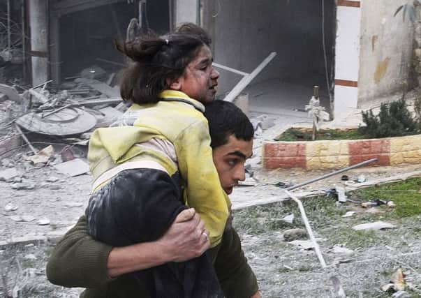 A Syrian man carries his sister who was wounded after a government airstrike hit the neighborhood of Ansari, in Aleppo, Syria,  as George Osborne criticised the West for a  lack of leadership.