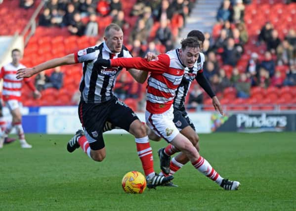Doncaster's Liam Mandeville holds off the Grimsby defenders