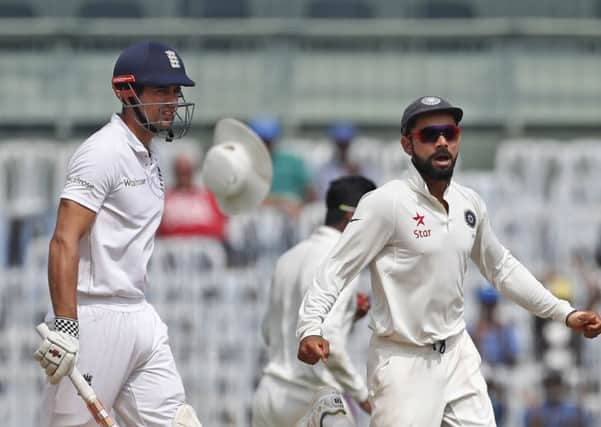 DOWNHILL FROM NOW ON: India's captain Virat Kohli, right, celebrates the dismissal of England's captain Alastair Cook Picture: AP/Tsering Topgyal