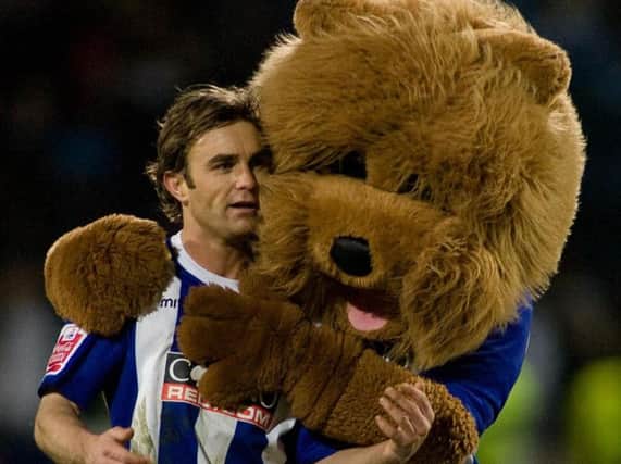 Chris Brandon celebrates victory with the Huddersfield mascot after the win (Photo: PA)