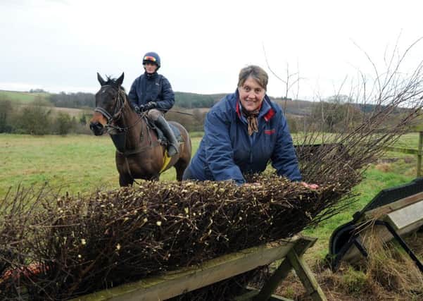 Cherry Coward who is one of Point to Point's best known Yorkshire trainers, watches jockey Jack Andrews over one of the jumps on her farm at Scackleton, near York.  Picture: Jonathan Gawthorpe