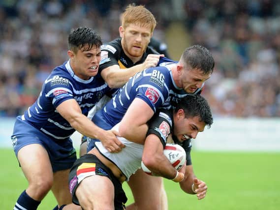 Kieren Moss tackled by Featherstone Rovers pair Michael Channing and Jordan Baldwinson