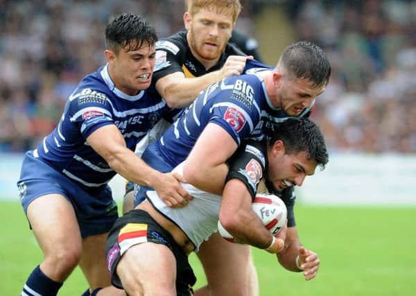Kieren Moss tackled by Featherstone Rovers pair Michael Channing and Jordan Baldwinson