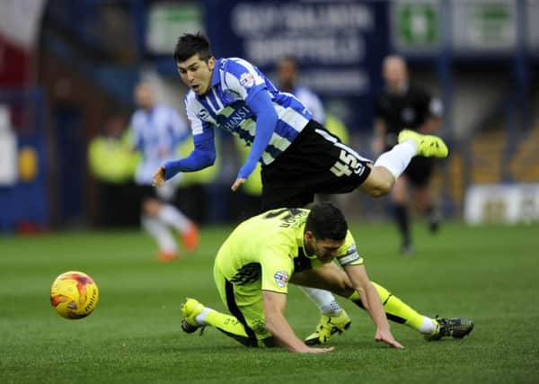Sheffield Wednesday's Fernando Forestieri is challenged by Huddersfield's Mark Hudson in last year's meeting at Hillsborough, which the hosts won 3-1.
