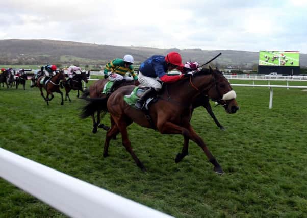 Old Guard ridden by Harry Cobden (red cap) on their way to victory in the StanJames.com Greatwood Hurdle during day three of The Open at Cheltenham racecourse, Cheltenham.