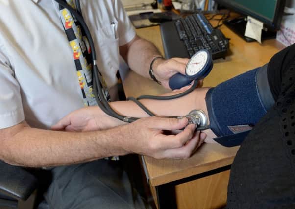 A doctor checking a patient's blood pressure. Credit: Anthony Devlin/PA Wire
