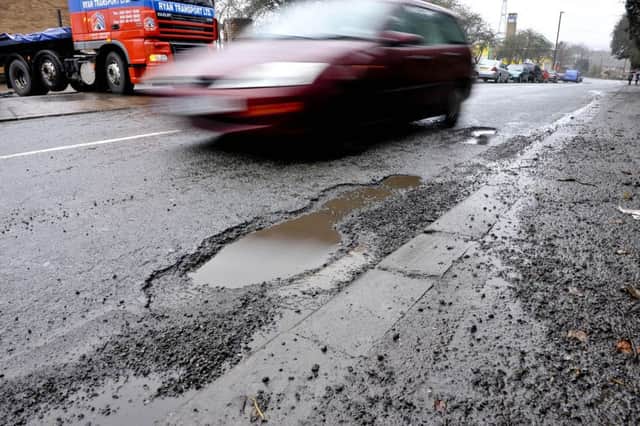 A car driving around a pothole, as councils have warned that 2017 could be a "tipping point" for tackling potholes