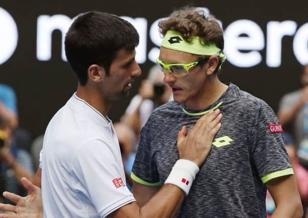 Uzbekistan's Denis Istomin, right, is congratulated by Serbia's Novak Djokovic