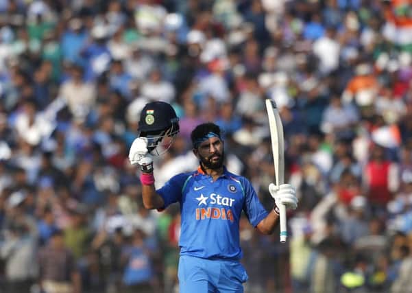 India's Yuvraj Singh raises his bat and helmet to celebrate scoring hundred runs against England in Cuttack on Thursday. Picture: AP/Aijaz Rahi
