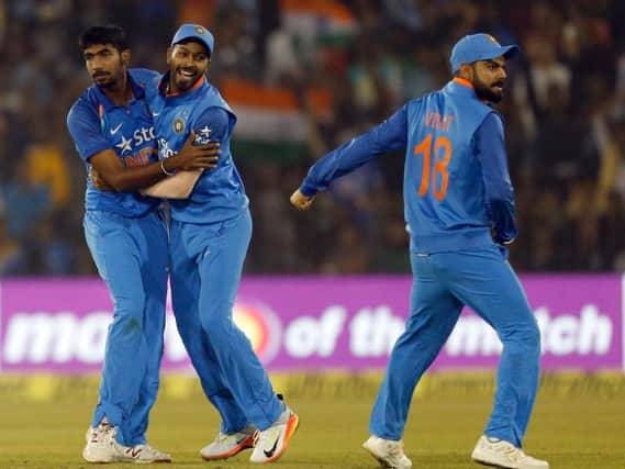 Indian cricketer Jasprit Bumrah, left, celebrates with teammate Hardik Pandya, center, and captain Virat Kohli the dismissal of England's Alex Hales (AP Photo/Aijaz Rahi)