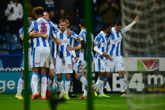 Huddersfield Town's Christopher Schindler, right, walks away after been mobbed by his teammates for scoring their second goal of the match. (Picture: James Hardisty)