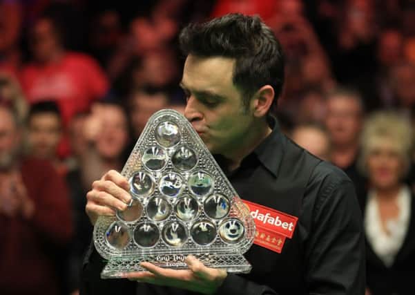 Ronnie O'Sullivan kisses the trophy following his victory over Joe Perry at the Dafabet Masters.