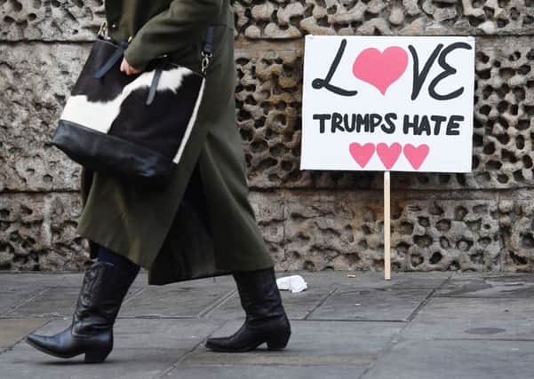 A woman walks past protest banners left in Duncannon Street, London, following a march on Saturday to promote women's rights in the wake of President Donald Trump's inauguration.