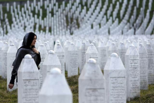 A woman walks among the gravestones at the Memorial Centre Potocari, near Srebrenica. (PA).