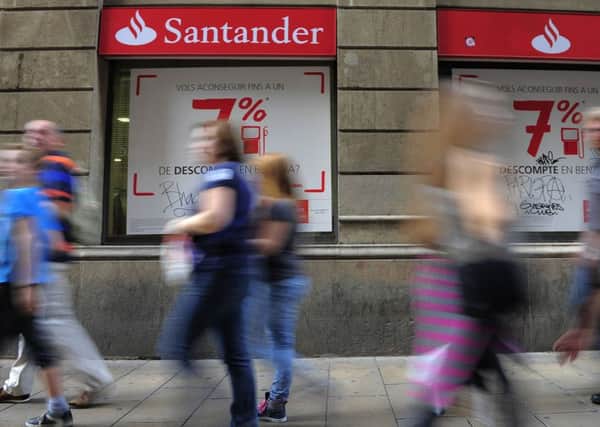 People walk past a Santander bank branch in Barcelona, Spain.  (AP Photo/Manu Fernandez)