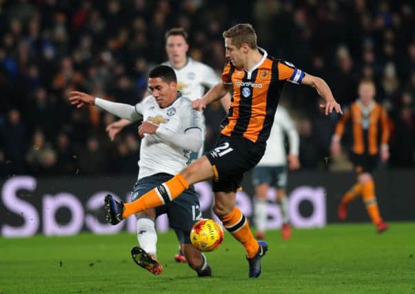 Hull's Michael Dawson has his shot blocked by Manchester United's Chris Smalling.