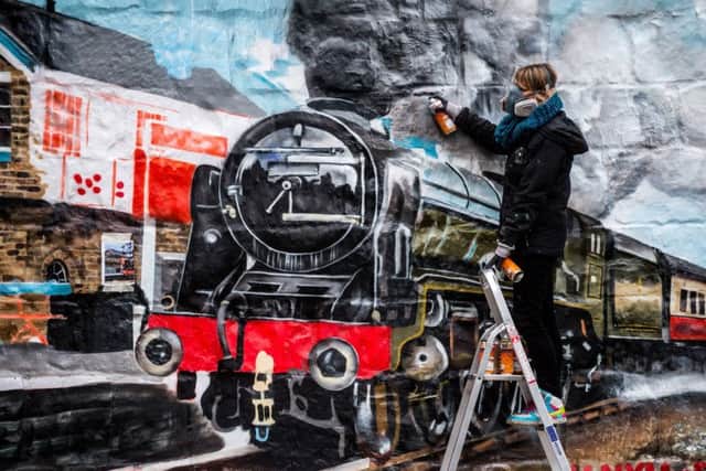 Artist Sophie, from Graffiti Life working on the mural. Picture James Hardisty