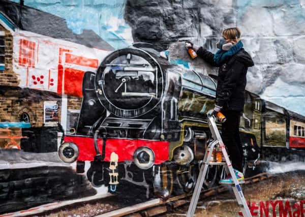 Artist Sophie, from Graffiti Life working on the mural. Picture James Hardisty