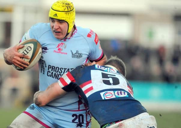 In it together: Jamie Tyas of Rotherham Titans is tackled by Glen Young of Doncaster Knights during the South Yorkshire rivals Championship fixture last month. Both clubs continue to fight against rising costs and slender income streams.  Picture: steve riding