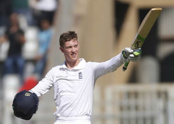 England's batsman Keaton Jennings raises his bat after scoring a century against India.