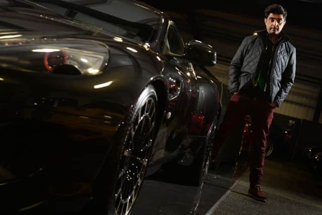 Top gear: Afzal Kahn at the Kahn Design showroom in Bradford stood next to an Aston Martin that his firm designed.  Picture: bruce rollinson